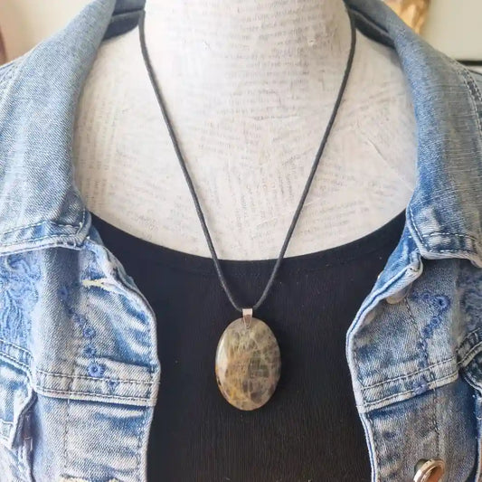 Pendentif pierre de lune noire porté au cou