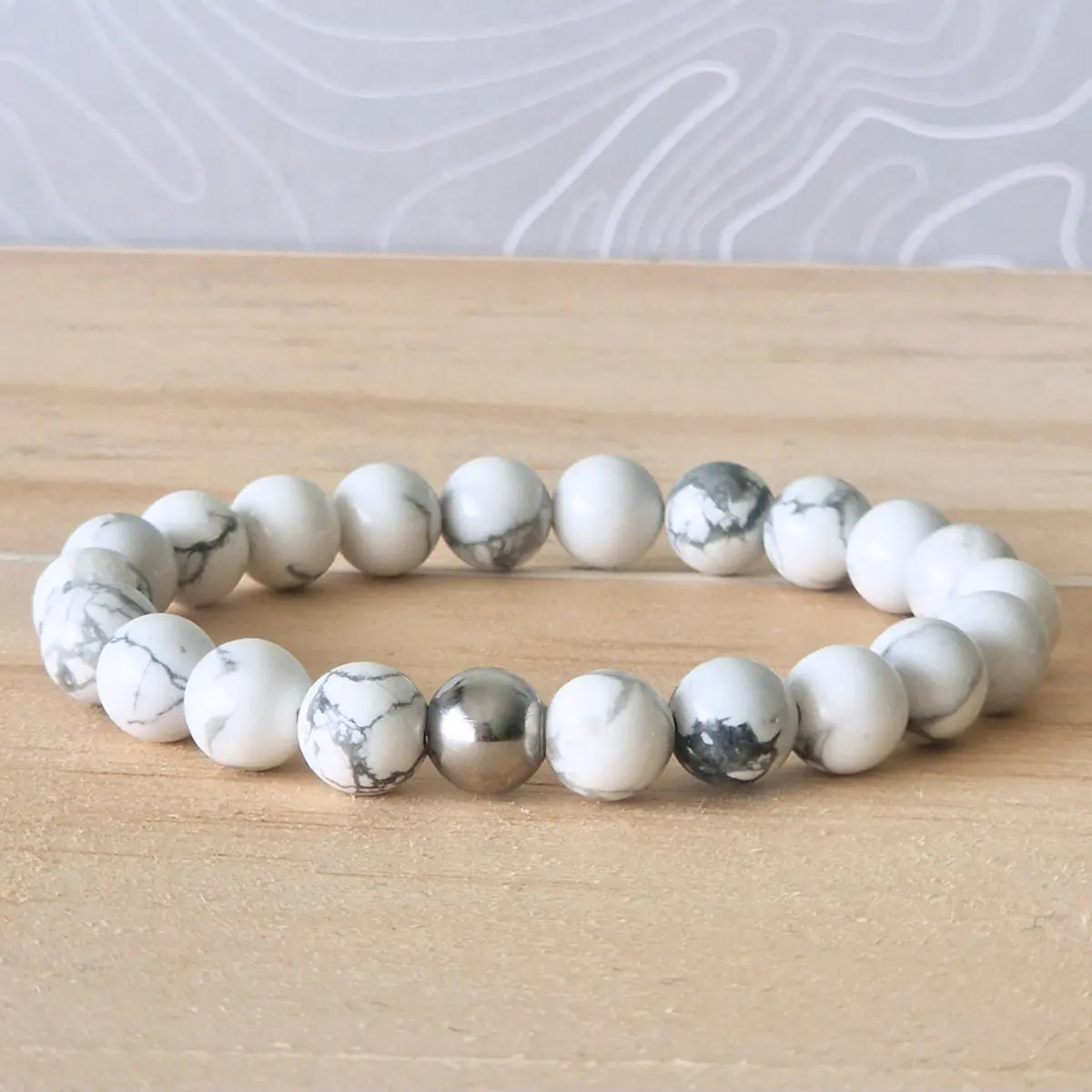 l'image est un bracelet de perles  8mm blanc avec des nervures grises de 17 cm  howlite pierre naturelle en howlite naturelle 8mm  blanche avec des nervures grises