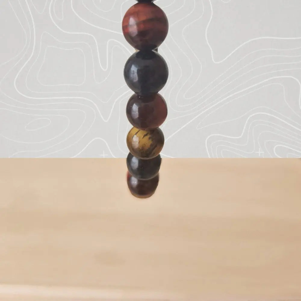 Détail des perles de pierres semi-précieuses : œil de tigre aux reflets dorés, œil de faucon aux nuances bleutées et œil de taureau aux tons chauds