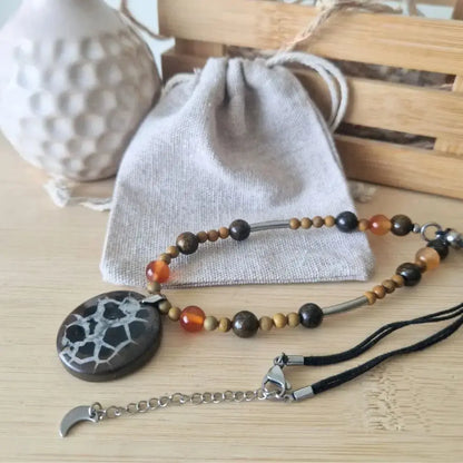 collier avec pendentif septaria noire & perles cornaline, jaspe bois avec pochon en lin